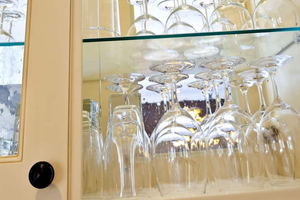 A kitchen cabinet full of different glasses