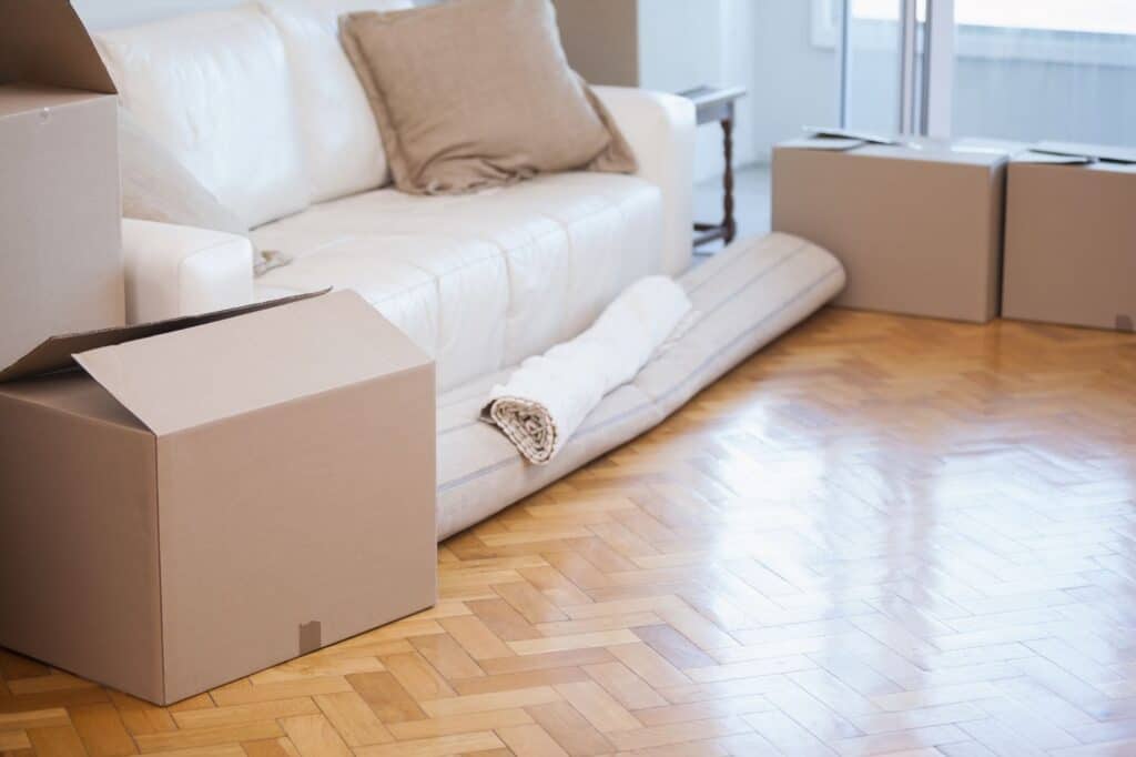 Cardboard boxes, sofa and rolled carpet in the concept of house move