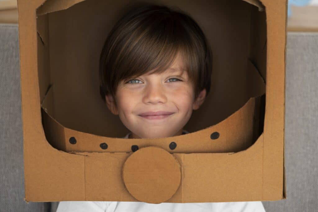 A kid wearing a DIY astronaut helmet made of cardboard