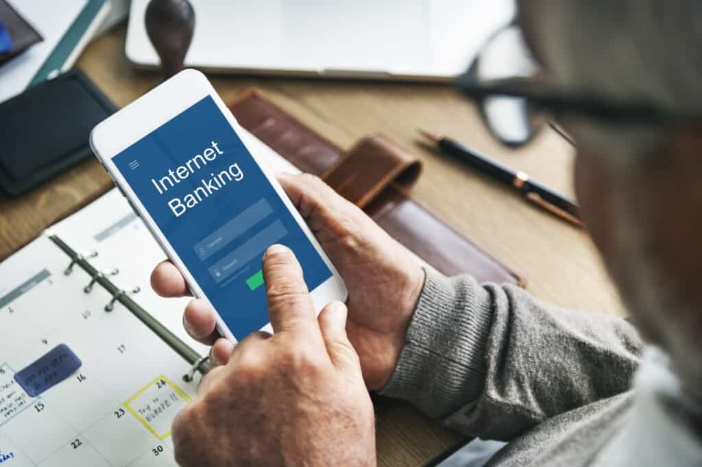 A senior woman logging into a bank mobile app to update her address
