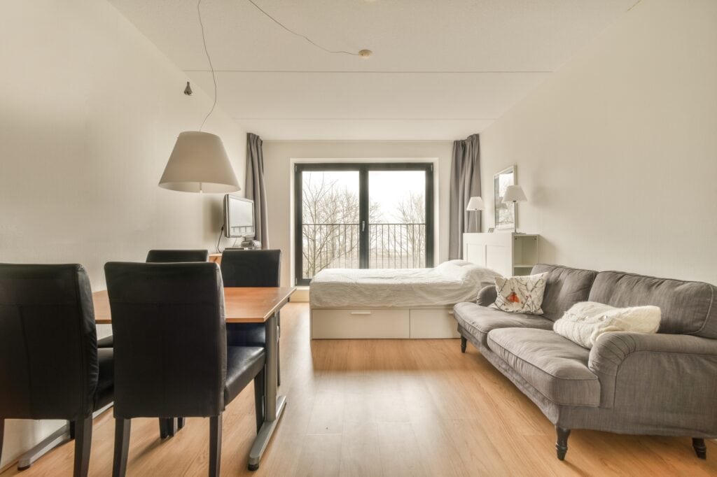 A spacious modern flat with bed, sofa, and dining table and chairs