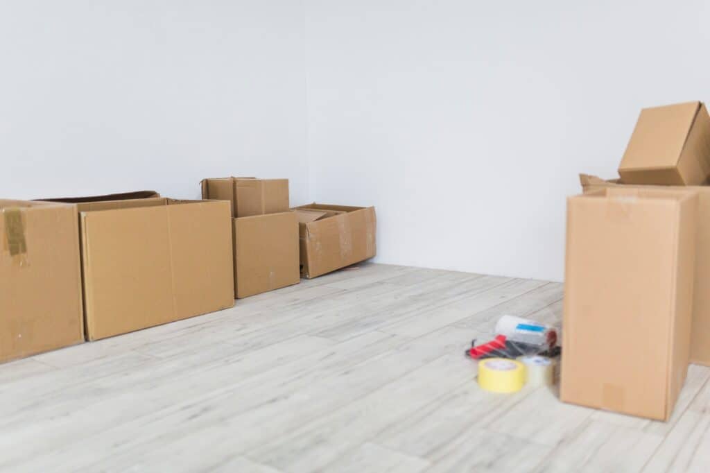 Moving boxes and packing tape on the old flat's floor before the relocation