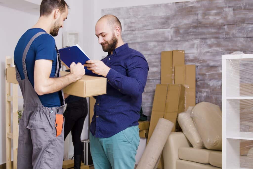 A couple arrived in their new home with the mover holding a clipboard